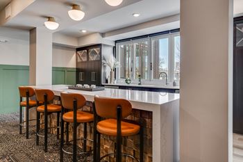 a bar area with stools and a fireplace